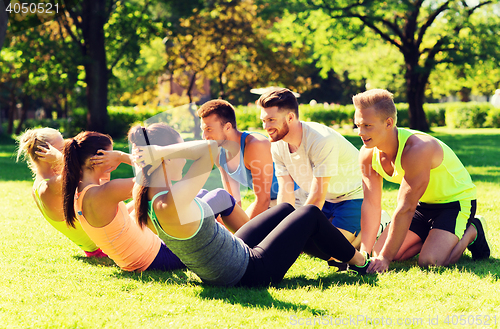 Image of group of friends or sportsmen exercising outdoors