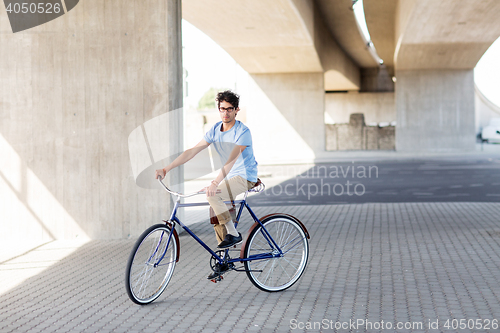 Image of young hipster man riding fixed gear bike