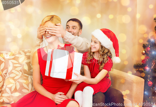 Image of father and daughter surprise mother with gift box