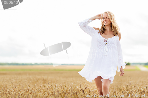 Image of smiling young woman in white dress on cereal field