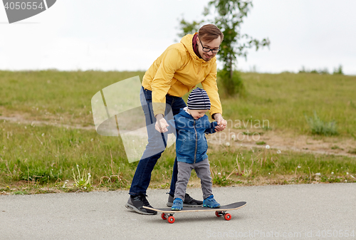 Image of happy father and little son on skateboard
