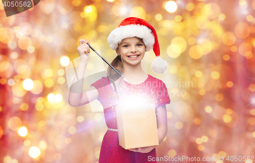 Image of girl in santa hat with gift box and magic wand