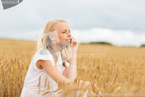 Image of happy young woman calling on smartphone at country