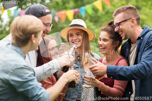 Image of happy friends clinking glasses at summer garden