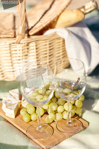 Image of picnic basket with wine glasses and food on beach