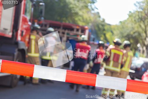 Image of Team of firefighters by firetruck on accident location.