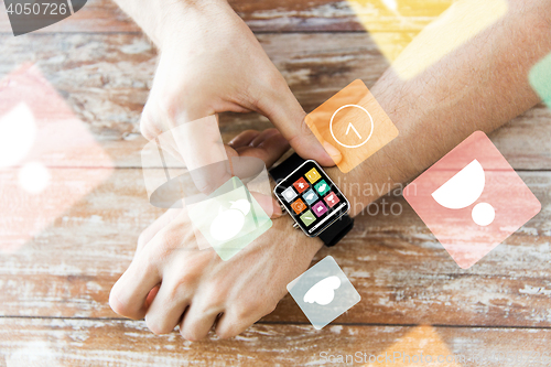 Image of close up of hands setting smart watch with icons