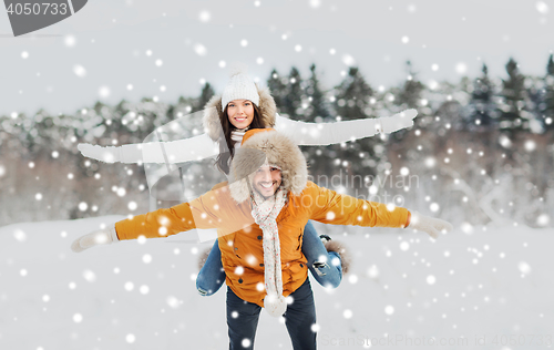 Image of happy couple having fun over winter background