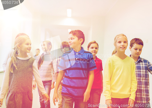 Image of group of smiling school kids walking in corridor