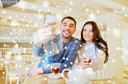 Image of couple taking smartphone selfie at cafe restaurant