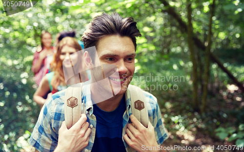 Image of group of smiling friends with backpacks hiking