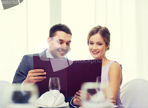 Image of smiling couple with menu at restaurant