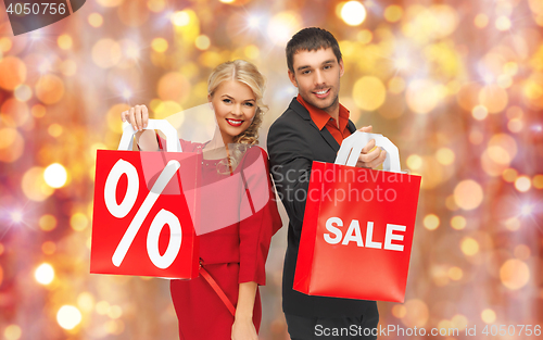 Image of couple with sale sign on shopping bags