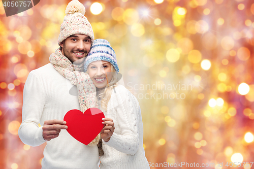 Image of smiling couple in winter clothes with red hearts