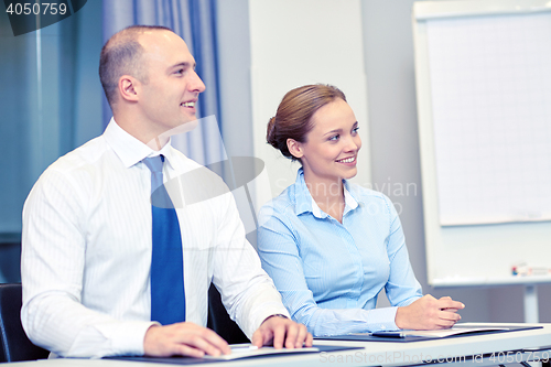 Image of group of smiling businesspeople meeting in office