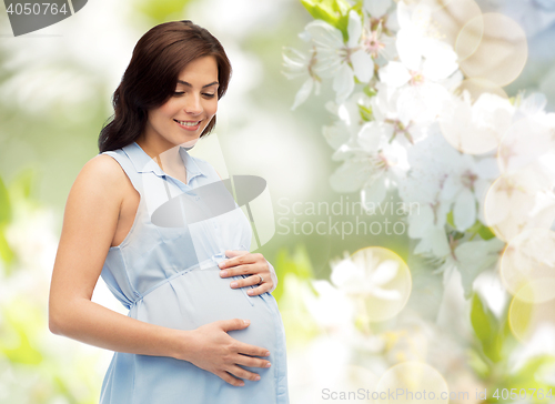 Image of happy pregnant woman touching her big belly