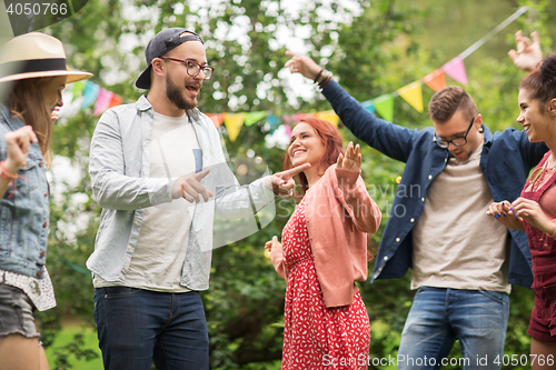 Image of happy friends dancing at summer party in garden