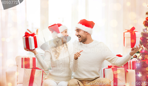 Image of happy couple with christmas gifts and thumbs up