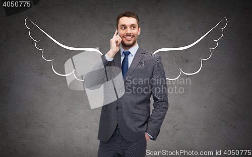 Image of businessman with angel wings calling on cellphone