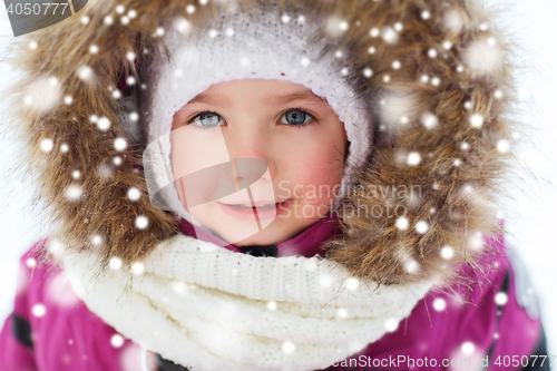 Image of face of happy little kid or girl in winter clothes