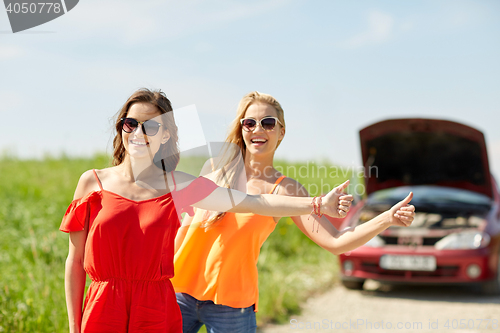 Image of women with broken car hitchhiking at countryside