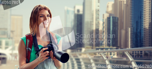 Image of woman with backpack and camera over dubai city