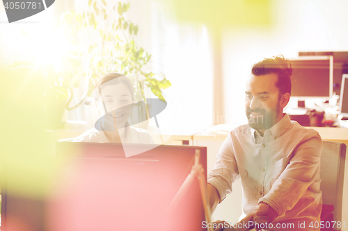 Image of happy creative team with computer in office