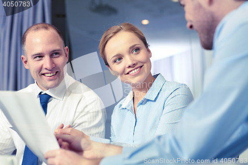 Image of business people with papers meeting in office