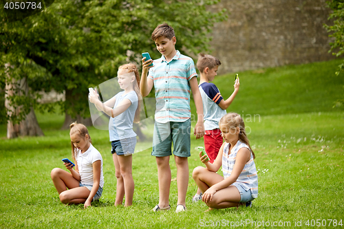 Image of kids with smartphones playing game in summer park