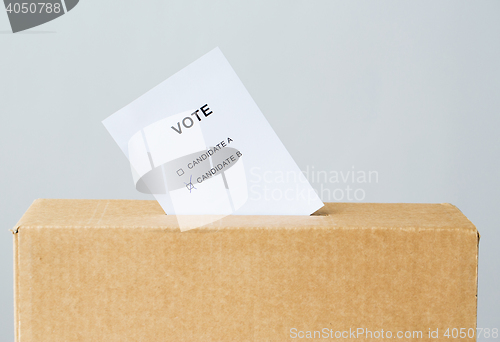 Image of vote inserted into ballot box slot on election