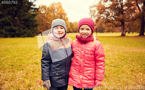 Image of happy little girl and boy in autumn park