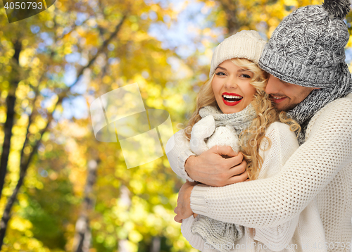 Image of happy couple in warm clothes over autumn