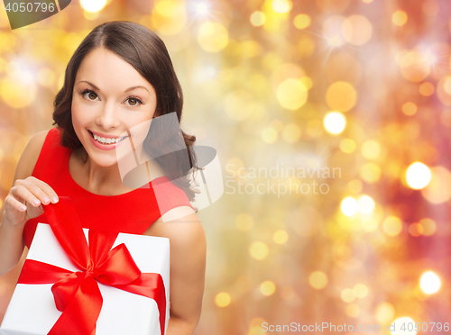 Image of smiling woman in red dress with christmas gift