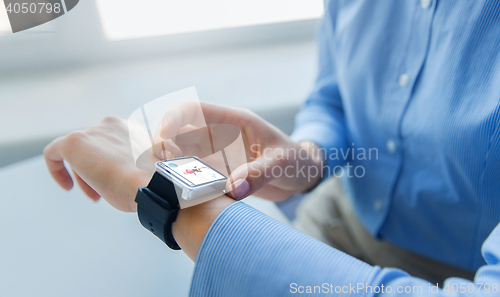 Image of close up of hands with fitness app on smart watch