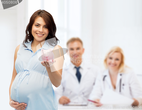 Image of happy pregnant woman with piggybank