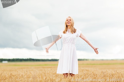 Image of smiling young woman in white dress on cereal field