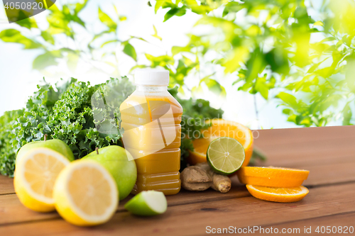 Image of bottle with orange juice, fruits and vegetables