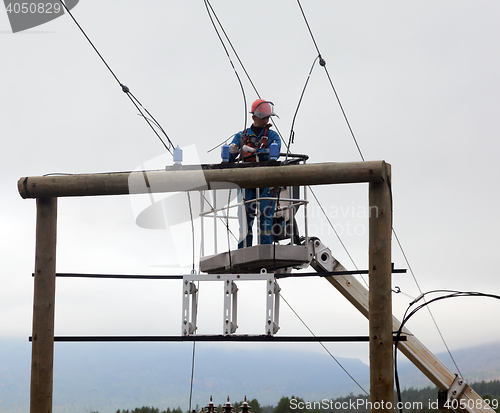 Image of Electrician working at a power transmission line construction