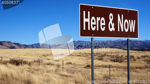 Image of Here and Now brown road sign