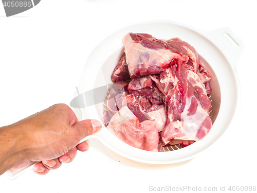 Image of Fresh red lamb meat in a colander after rinsing in water