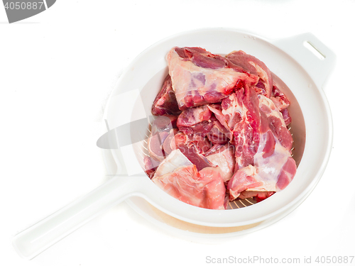 Image of Fresh red lamb meat in a colander after rinsing in water