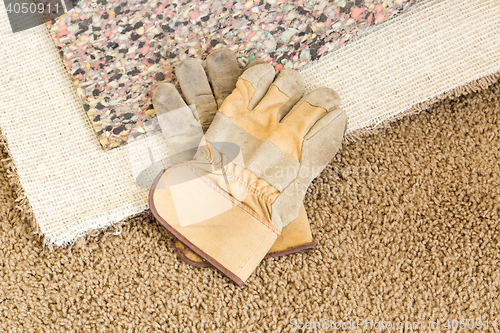 Image of Gloves On Pulled Back Carpet and Pad In Room