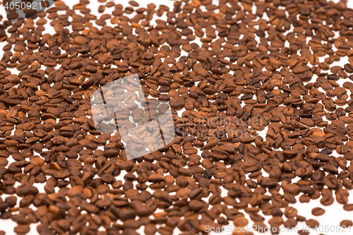 Image of Black coffee beans on white table,