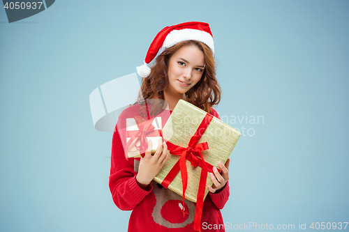 Image of Girl dressed in santa hat with a Christmas gifts
