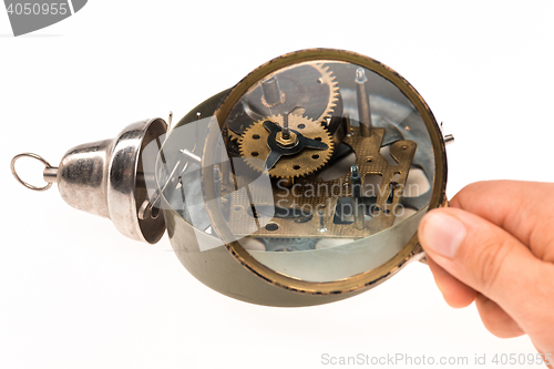 Image of The male hand with magnifier and clockwork
