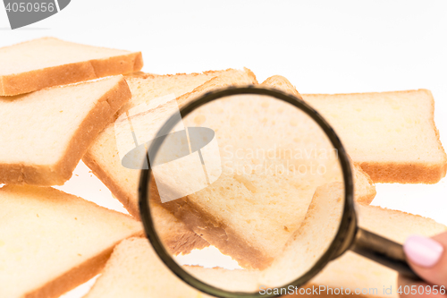 Image of View through a magnifying glass to toast bread on the table. Wheat.