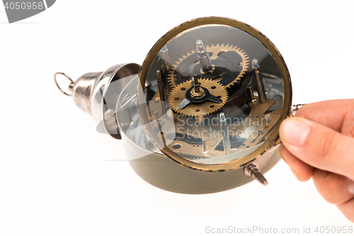 Image of The male hand with magnifier and clockwork