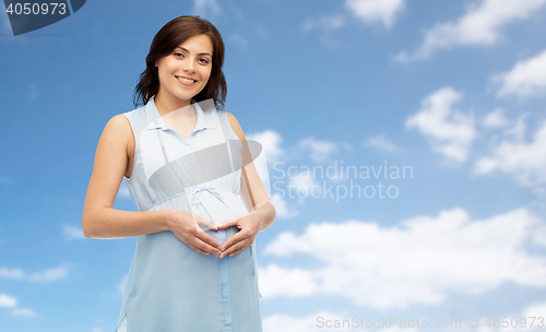 Image of happy pregnant woman making heart gesture
