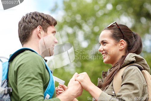 Image of happy couple with backpacks hiking outdoors