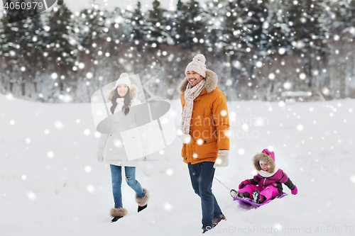 Image of happy family with sled walking in winter forest